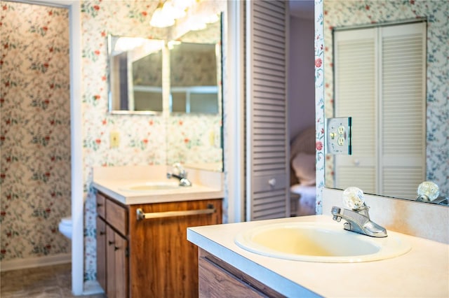 4976 Pleasant Hollow Trl, Lakeland, FL 33811 - bathroom featuring a sink, baseboards, wallpapered walls, and two vanities