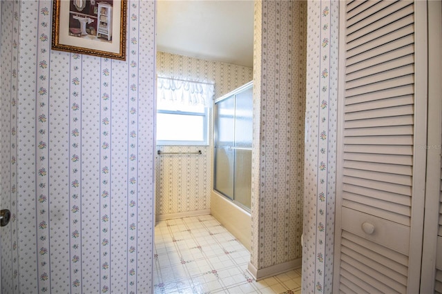 4976 Pleasant Hollow Trl, Lakeland, FL 33811 - full bath with baseboards, a closet, wallpapered walls, and shower / bath combination with glass door