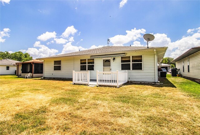4976 Pleasant Hollow Trl, Lakeland, FL 33811 - back of house featuring central air condition unit, a sunroom, and a yard