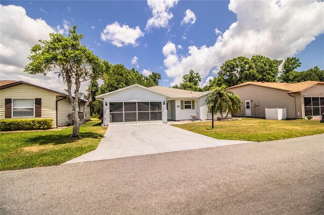 4976 Pleasant Hollow Trl, Lakeland, FL 33811 - ranch-style home with a sunroom, driveway, and a front lawn