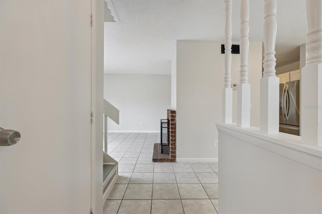 corridor featuring light tile patterned floors and baseboards