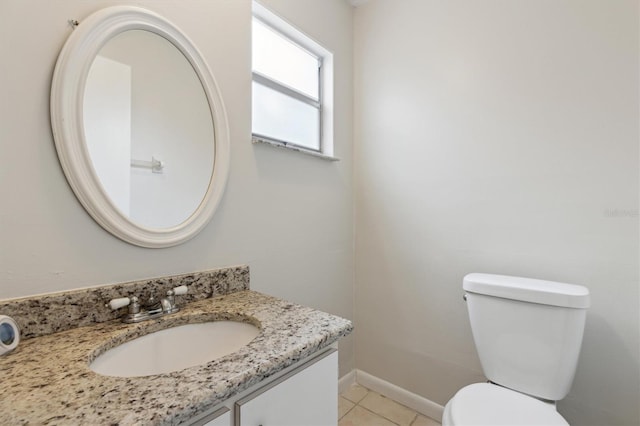 bathroom featuring vanity, tile patterned flooring, toilet, and baseboards