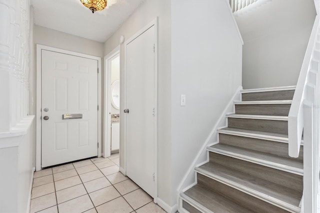 foyer featuring light tile patterned flooring and stairway