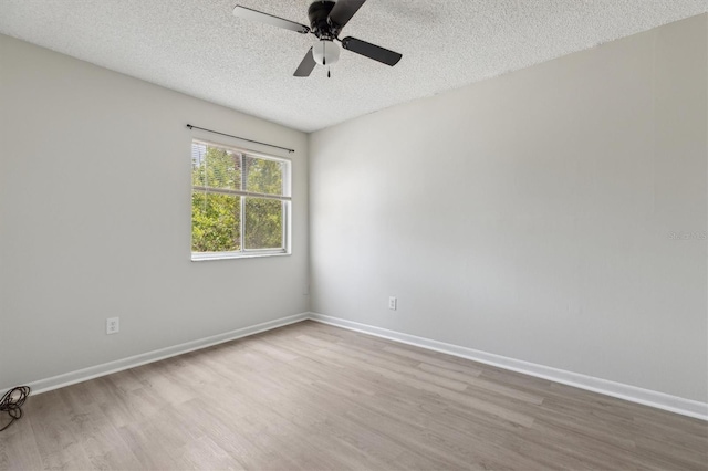 empty room featuring wood finished floors, a textured ceiling, ceiling fan, and baseboards