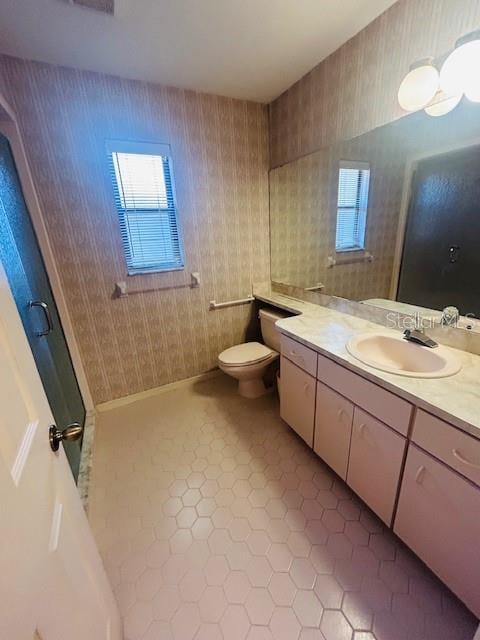 bathroom featuring toilet, wallpapered walls, tile patterned flooring, and vanity