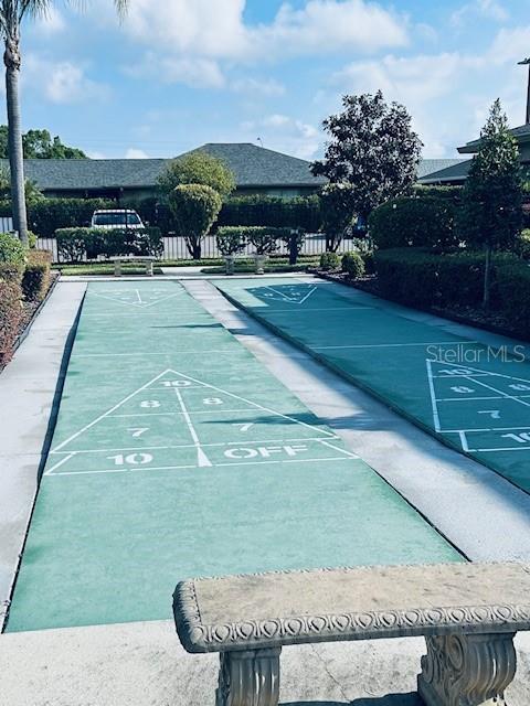 view of home's community featuring fence and shuffleboard