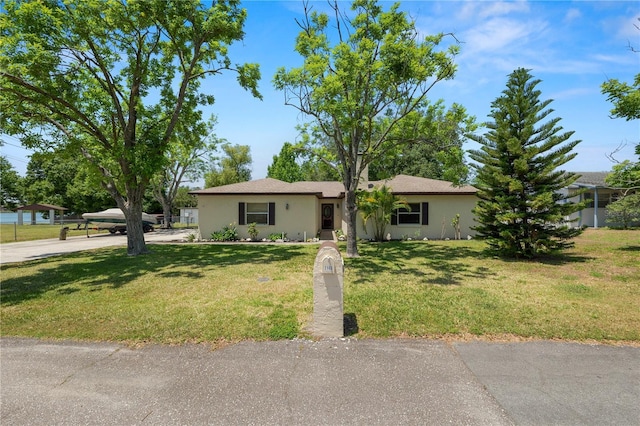 single story home featuring a front lawn and stucco siding