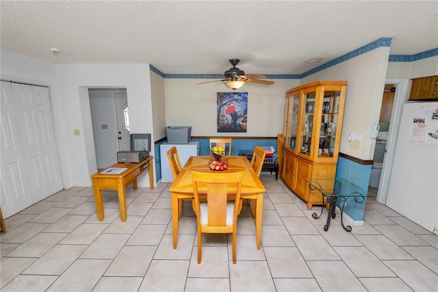 dining space with a ceiling fan, a textured ceiling, and light tile patterned flooring