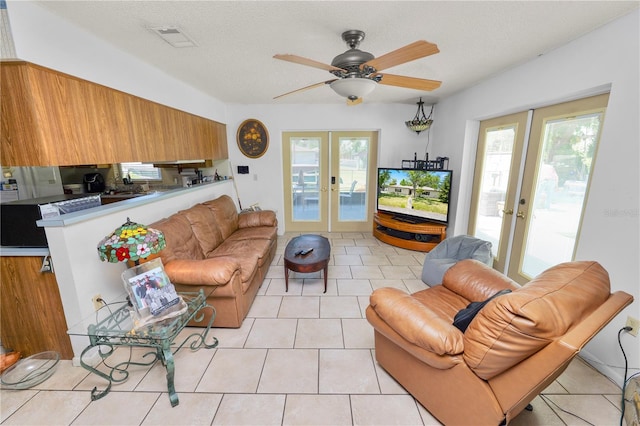 living area with light tile patterned floors, ceiling fan, french doors, and visible vents