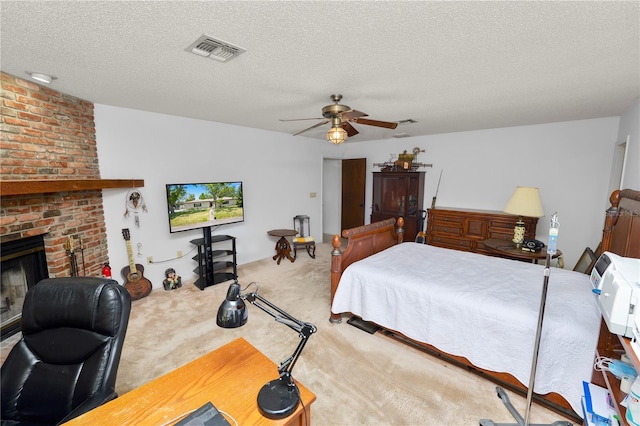 bedroom featuring visible vents, a textured ceiling, carpet floors, and a fireplace