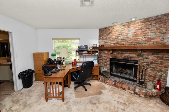 home office featuring visible vents, a textured ceiling, carpet, and a fireplace
