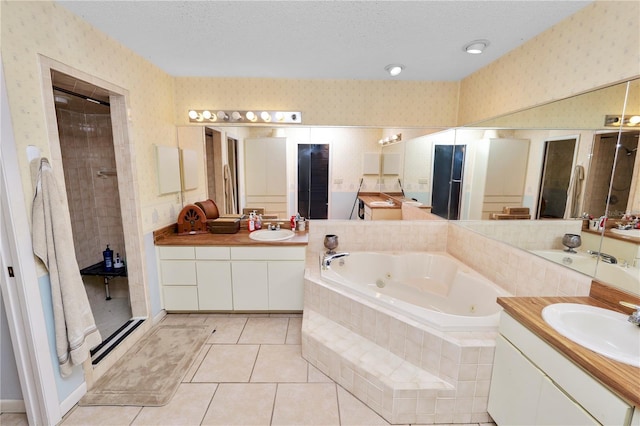 bathroom featuring a sink, a whirlpool tub, and wallpapered walls