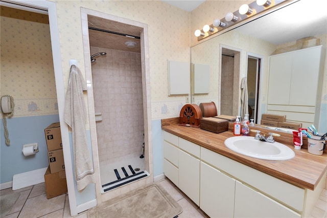 full bathroom featuring vanity, tile patterned flooring, wallpapered walls, and tiled shower
