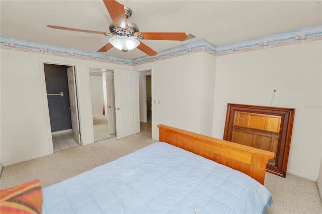 bedroom with baseboards, a textured ceiling, connected bathroom, and light carpet