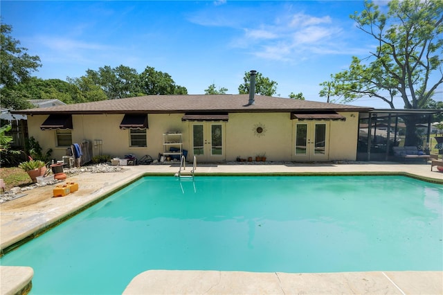 outdoor pool featuring french doors, a patio, and a sunroom