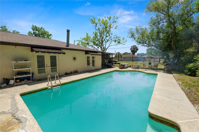 outdoor pool with a patio area and french doors