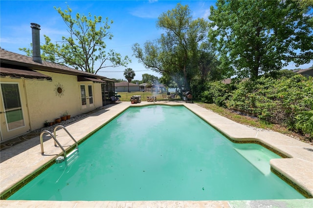 outdoor pool with french doors, a fenced backyard, and a patio area