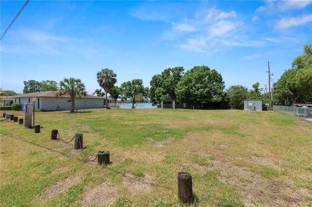 view of yard featuring fence and an outbuilding