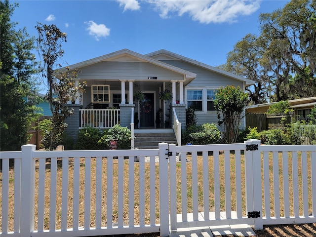bungalow-style house with covered porch and a fenced front yard