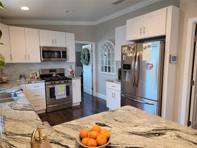 kitchen featuring white cabinets, light stone counters, dark wood finished floors, stainless steel appliances, and tasteful backsplash