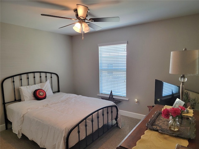 carpeted bedroom with baseboards, multiple windows, and a ceiling fan