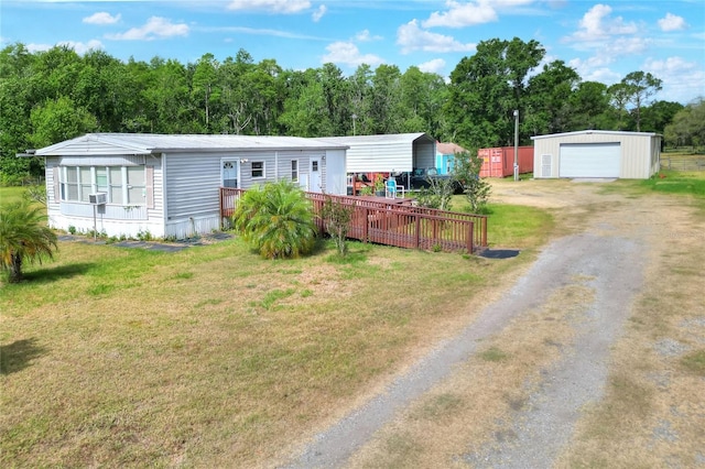 manufactured / mobile home featuring an outbuilding, a front lawn, driveway, and a detached garage