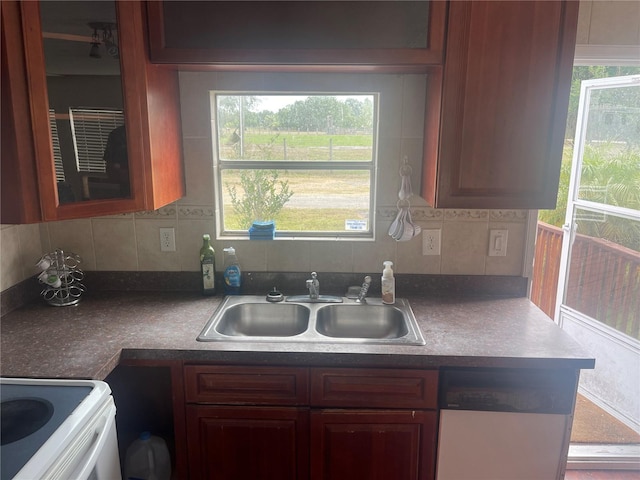 kitchen featuring stainless steel dishwasher, white range with electric cooktop, plenty of natural light, and a sink