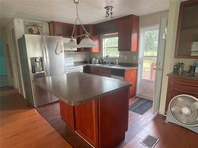 kitchen with decorative backsplash, dark wood-style flooring, visible vents, a sink, and stainless steel appliances