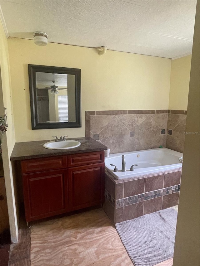 bathroom featuring a textured ceiling, a garden tub, and vanity