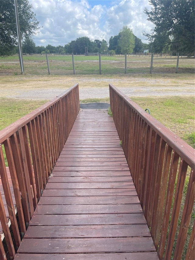 wooden deck with a lawn and a rural view