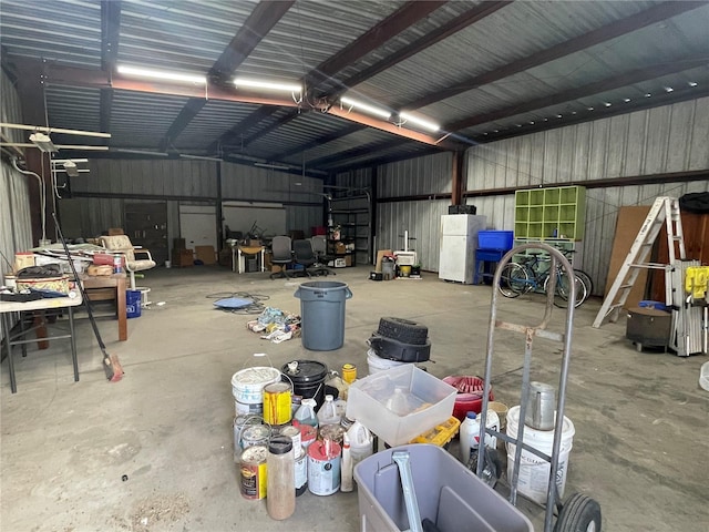 garage with freestanding refrigerator and metal wall