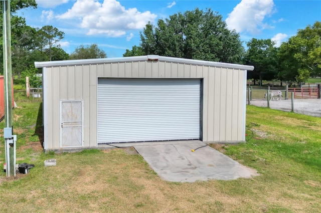 view of outbuilding with an outdoor structure, fence, and driveway