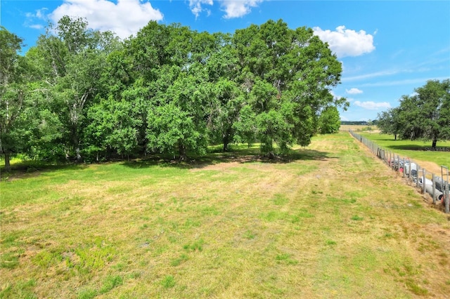 view of yard with a rural view and fence