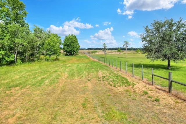 view of yard featuring fence and a rural view