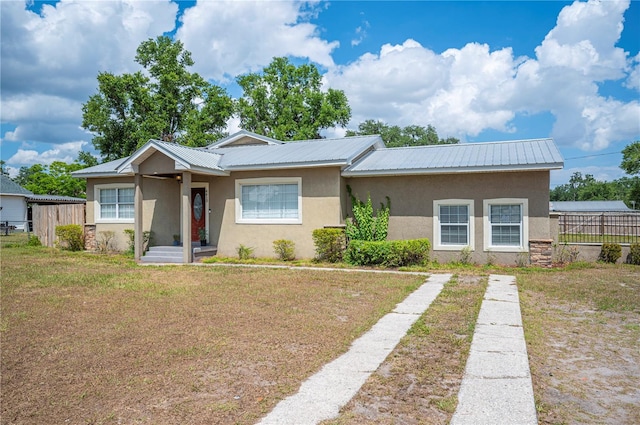 single story home with stucco siding and metal roof