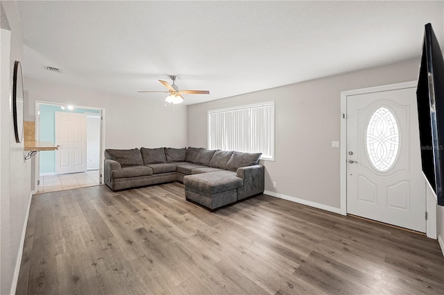 living room with wood finished floors, ceiling fan, healthy amount of natural light, and baseboards