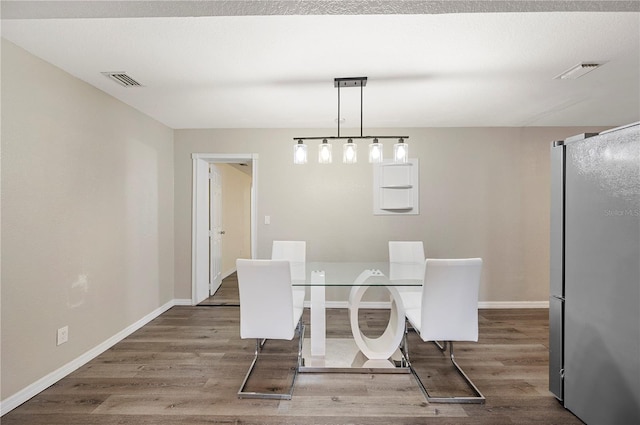 dining room featuring wood finished floors and baseboards