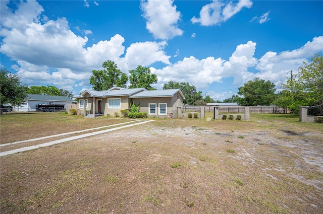 ranch-style house featuring stucco siding, fence, and metal roof