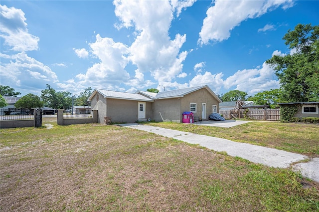 ranch-style house with stucco siding, metal roof, a patio, and a gate