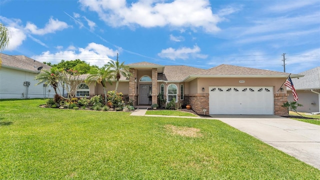 view of front of home featuring a front yard, stucco siding, brick siding, an attached garage, and driveway
