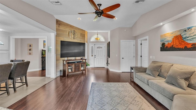 living room featuring ceiling fan, vaulted ceiling, wood finished floors, and visible vents