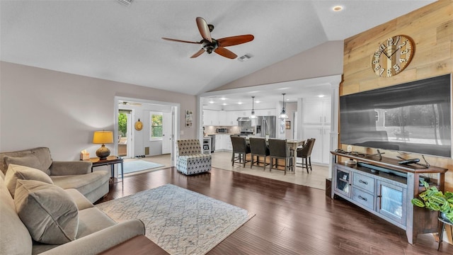 living area featuring ceiling fan, vaulted ceiling, wood finished floors, and visible vents