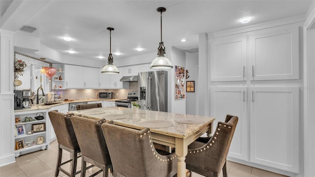 kitchen with visible vents, open shelves, a sink, under cabinet range hood, and stainless steel appliances