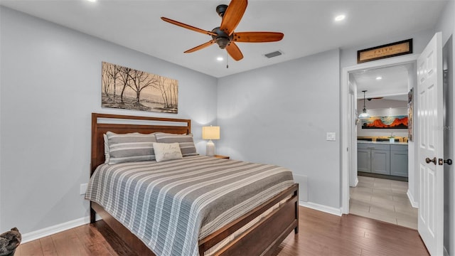 bedroom featuring baseboards, recessed lighting, wood finished floors, and visible vents