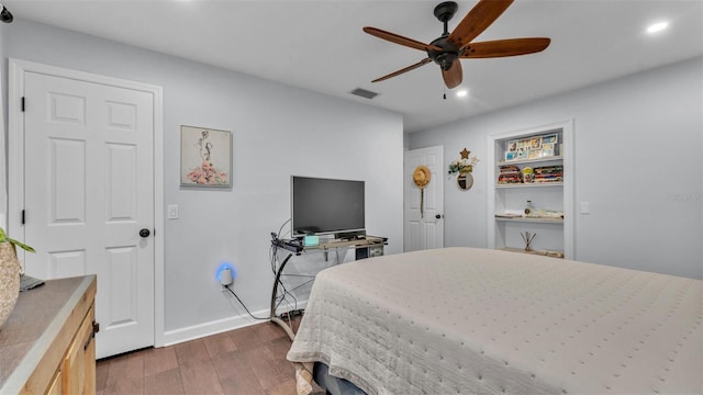 bedroom with baseboards, recessed lighting, wood finished floors, and visible vents