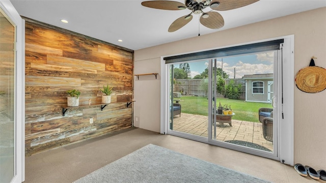entryway with recessed lighting, ceiling fan, and wooden walls