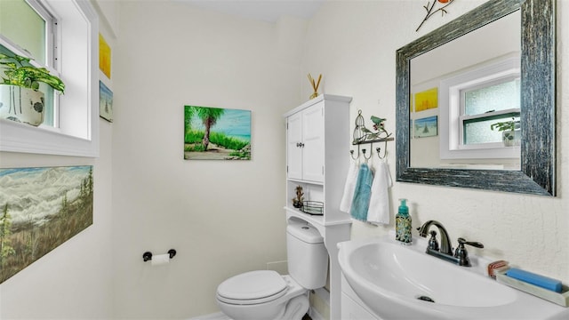 bathroom featuring baseboards, vanity, and toilet