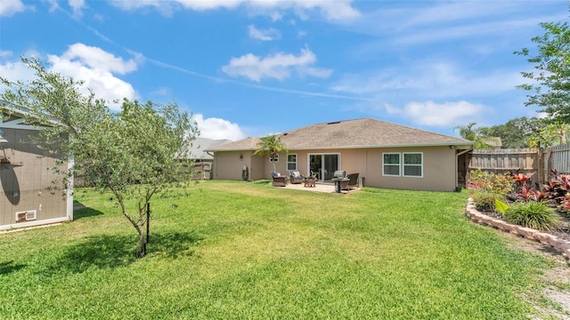 rear view of house with fence, a patio, stucco siding, and a yard