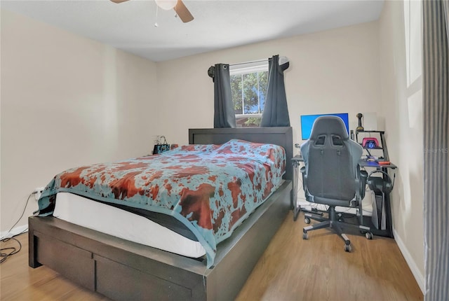 bedroom featuring baseboards, ceiling fan, and wood finished floors