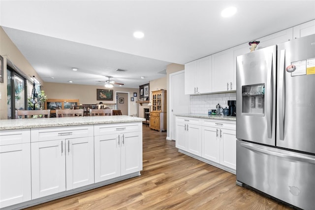 kitchen with white cabinetry, light wood finished floors, and stainless steel fridge with ice dispenser